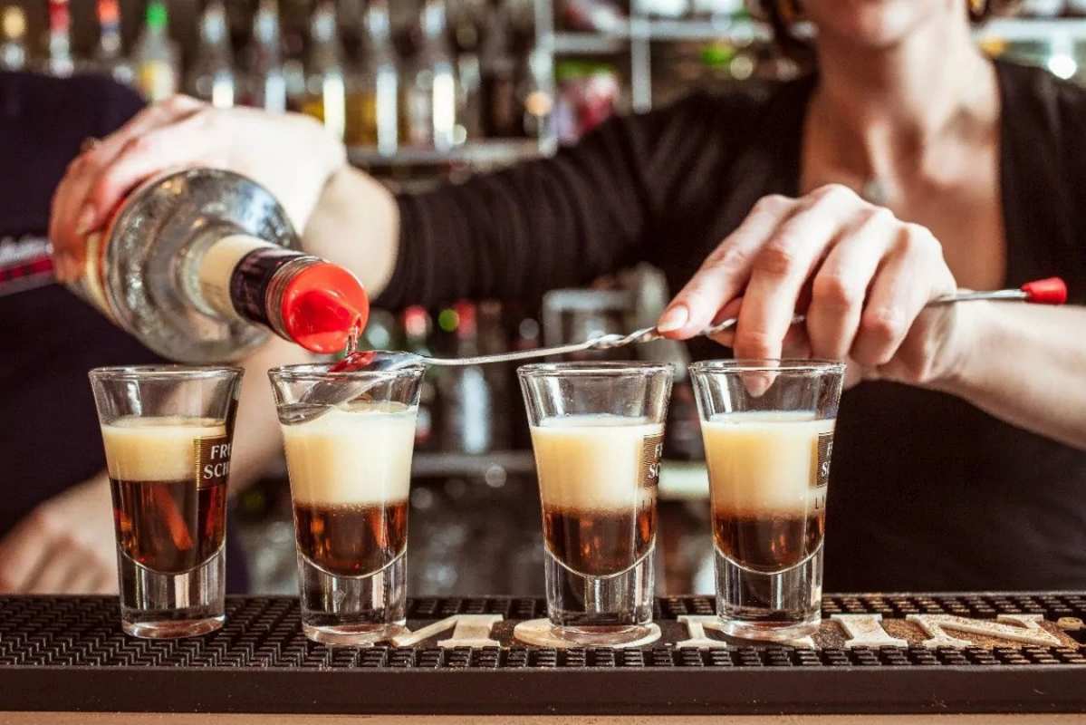 Открытка бармен наливает 4и стопки  с днем бармена  happy bartender day 