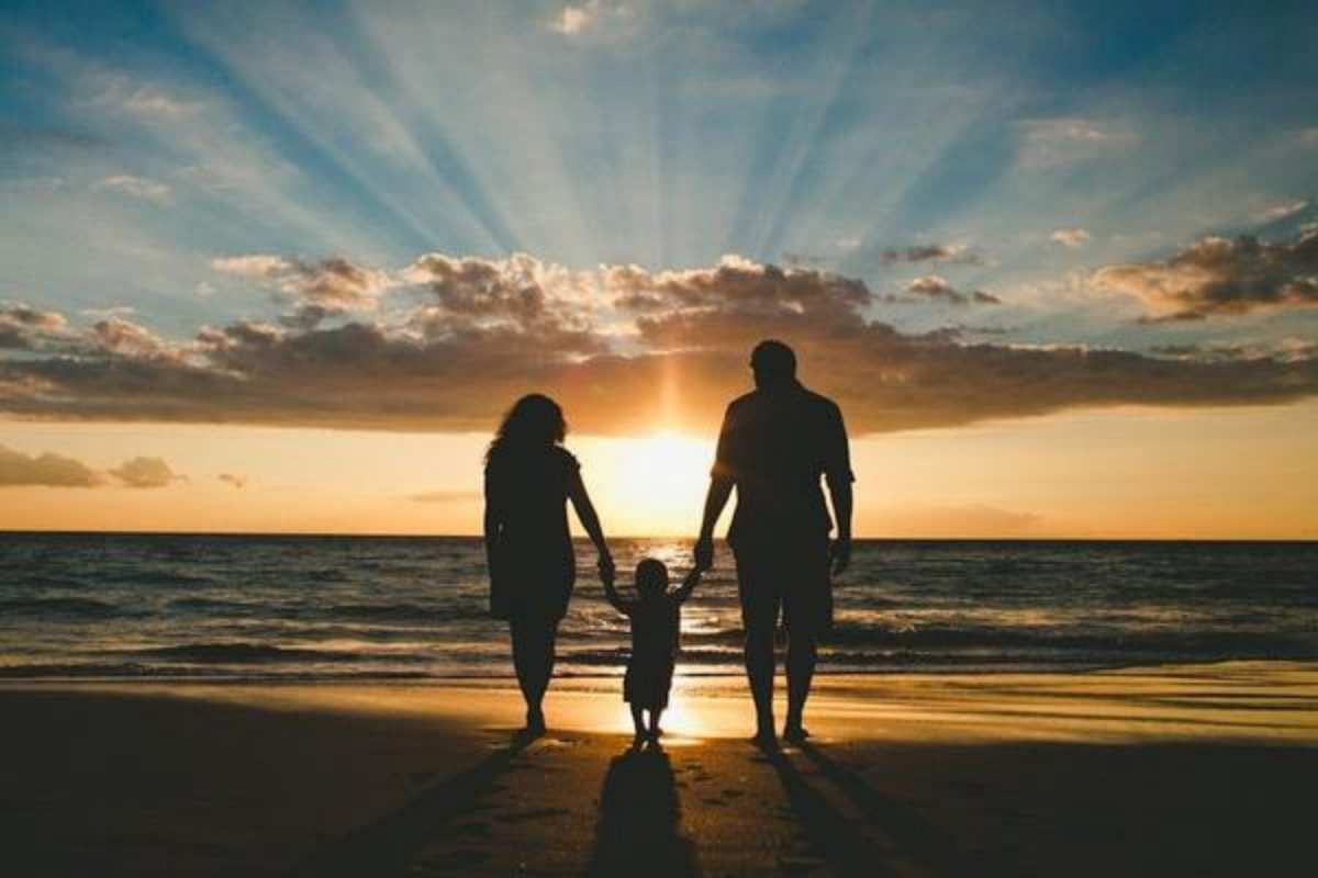 Открытка Мама и папа держат ребенка за руки. Закат на море, морской пляж  Море, пляж, закат, семья  happy family day 